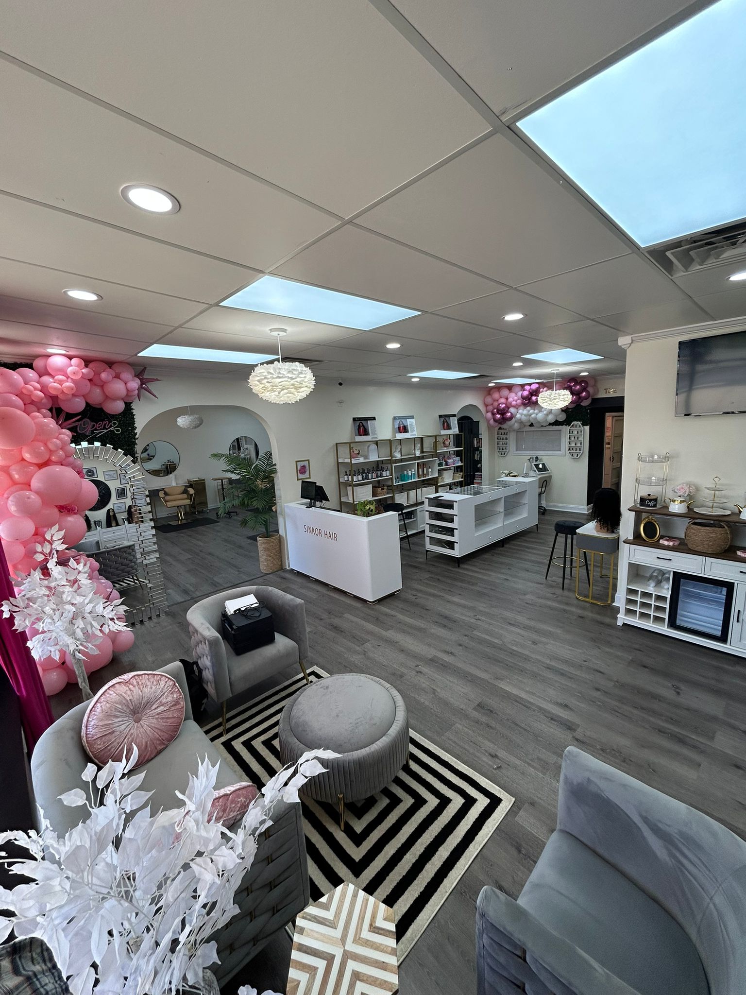 Sinkor storefront with SINKOR HAIR counter, product shelves, and balloon garland