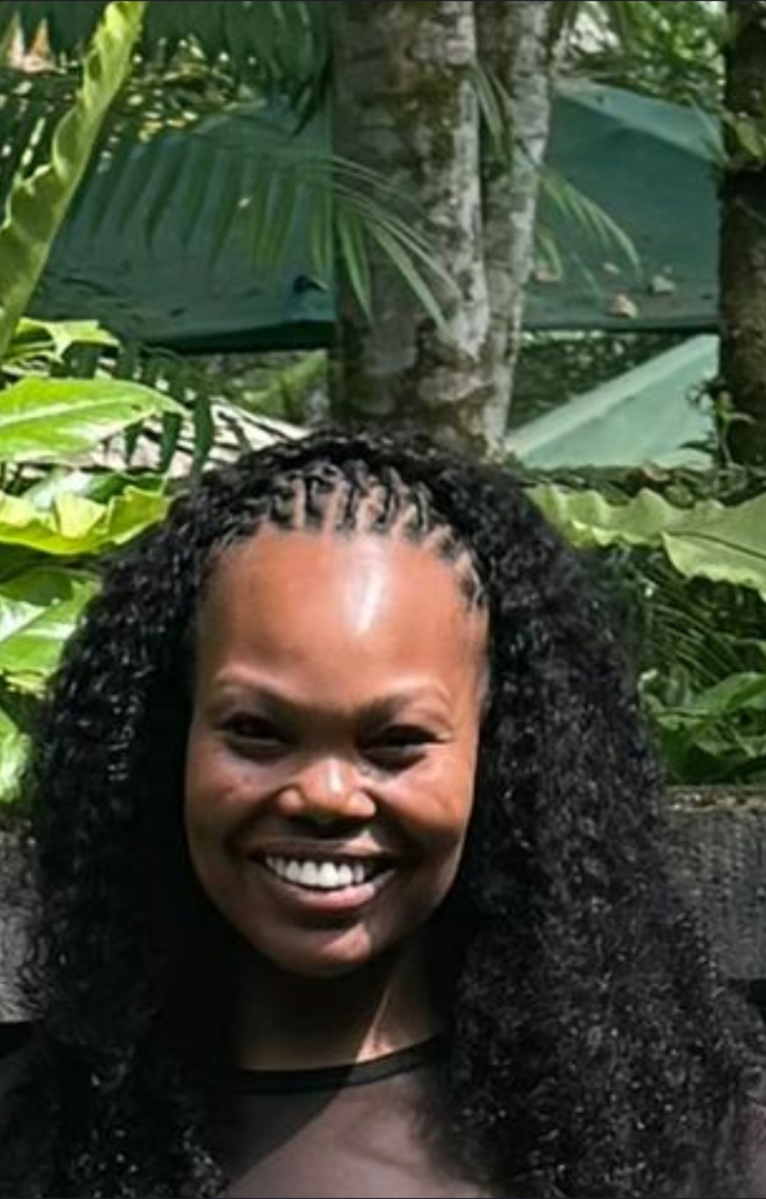 Young man with free-hanging locs in Under Armour jacket — men's locs Sinkor Beauty Salon Delaware