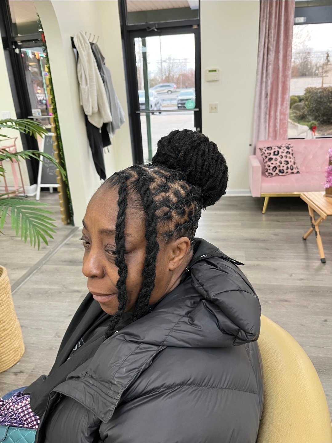 Woman with locs in bun updo wearing black puffer jacket — loc updo styling Delaware